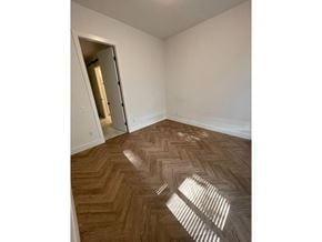 Surrey apartment for rent - A room with a wooden floor and a doorway leading to another room.