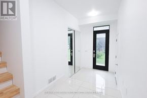 Welland (Lincoln/Crowland) townhouse for rent - A hallway with a glass door and a wooden staircase.