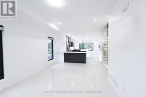 Welland (Lincoln/Crowland) townhouse for rent - A spacious, white-walled room with a black counter and a staircase on the right side.