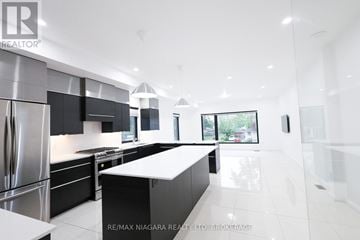 Welland (Lincoln/Crowland) townhouse for rent - A modern kitchen with a stainless steel refrigerator and black cabinets.