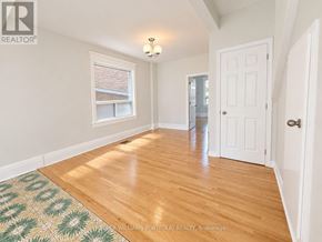 Toronto (Dovercourt-Wallace Emerson-Junction) apartment for rent - A room with a wooden floor and a rug with a geometric pattern.