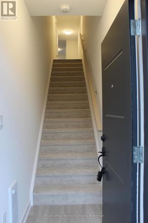 Guelph (Clairfields/Hanlon Business Park) townhouse for rent - A staircase with a black door on the right side.