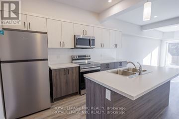 Thorold (Thorold Downtown) multi-family for rent - A kitchen with a refrigerator, microwave, oven, sink and cabinets.