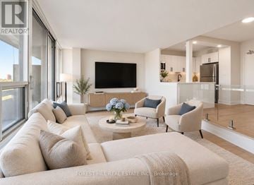 Toronto (Briar Hill-Belgravia) condo for rent - A living room with a white couch and a flat screen TV.