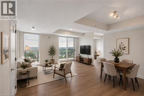 Brantford condo for rent - A well-lit, spacious living room with a dining area and a view of the city.