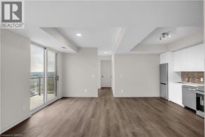 Brantford condo for rent - A spacious, well-lit kitchen and living room with hardwood floors and modern appliances.