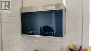 Hamilton (Crown Point) apartment for rent - A wall-mounted TV is mounted on a white tiled wall.