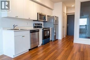 Brantford condo for rent - A modern kitchen with white cabinets and stainless steel appliances.