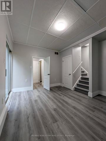 Barrie (Letitia Heights) townhouse for rent - A spacious room with wooden floors and white walls.