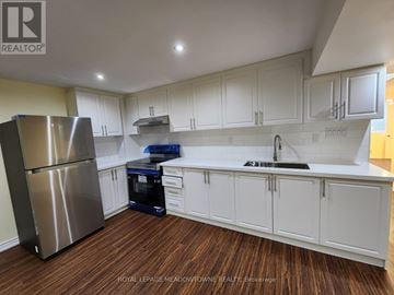 Milton (Be Beaty) apartment for rent - A kitchen with white cabinets and a stainless steel refrigerator.