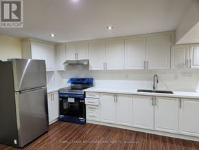 Milton (Be Beaty) apartment for rent - A kitchen with white cabinets and a stainless steel refrigerator.