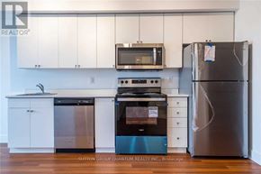 Brant (Brantford Twp) condo for rent - A kitchen with a refrigerator, oven, and microwave.