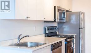 Brant (Brantford Twp) condo for rent - A kitchen with a stove, sink, and refrigerator.