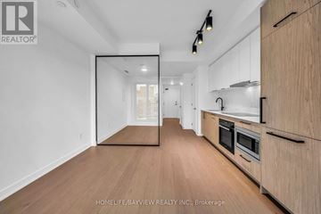 Toronto (Forest Hill South) condo for rent - A spacious kitchen with wooden cabinets and a large mirror on the wall.