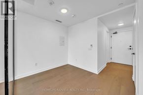 Toronto (Forest Hill South) condo for rent - A room with white walls and wooden flooring, with a door on the right side.