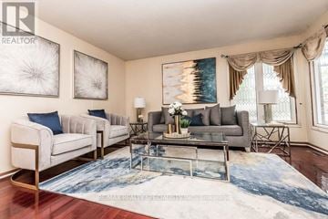 Mississauga (Hurontario) apartment for rent - A living room with a grey couch, a white chair, and a coffee table with a vase of flowers on it.