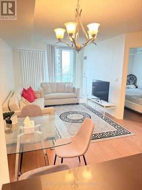 Mississauga (City Centre) condo for rent - A well-lit, modern living room with a glass table and a white sofa.