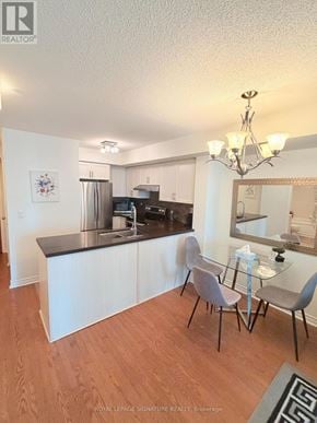 Mississauga (City Centre) condo for rent - A kitchen with white cabinets and a black counter top.