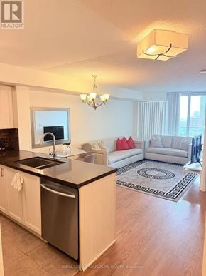 Mississauga (City Centre) condo for rent - A kitchen with a black counter top and white cabinets.