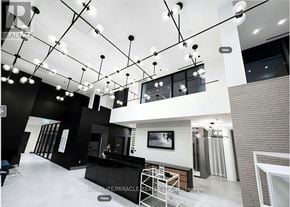 Milton (Tm Timberlea) apartment for rent - A modern interior space with a black and white color scheme and a unique lighting fixture.