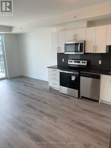 Waterloo condo for rent - A kitchen with white cabinets and a black countertop.