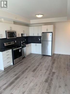 Waterloo condo for rent - A kitchen with white cabinets and a grey floor.
