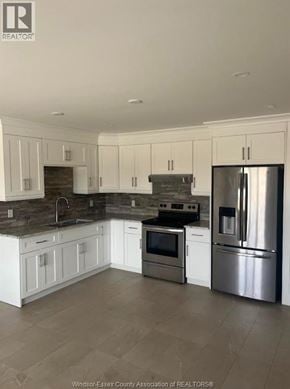 Windsor apartment for rent - A kitchen with white cabinets and a stainless steel refrigerator.