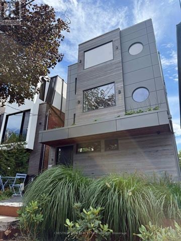 Toronto (North Riverdale) apartment for rent - A modern house with a wooden exterior and large windows.