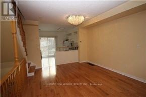 Markham (Commerce Valley) townhouse for rent - A large, empty room with wooden floors and a chandelier.