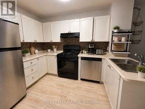 Ottawa townhouse for rent - A kitchen with white cabinets and a stainless steel refrigerator.