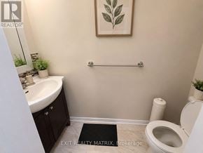 Ottawa townhouse for rent - A bathroom with a toilet, sink, and a plant.
