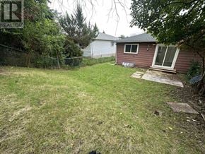 Toronto (Pleasant View) apartment for rent - A backyard with a brown house and a green lawn.