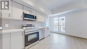Toronto (Tam O'shanter-Sullivan) townhouse for rent - A kitchen with white cabinets and a stainless steel oven.