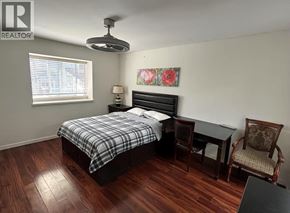 Vancouver apartment for rent - A bedroom with a bed, desk, chair, and a painting on the wall.