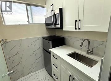 Vancouver apartment for rent - A kitchen with a sink, dishwasher, and microwave.