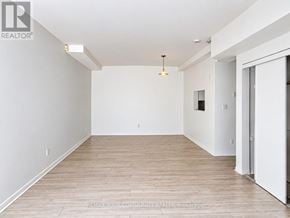 Richmond Hill (Mill Pond) condo for rent - A large, empty room with wooden flooring and white walls.