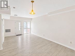 Richmond Hill (Mill Pond) condo for rent - A large, empty room with a wooden floor and a hanging light fixture.