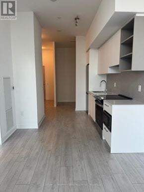 Brampton (Fletcher's Creek South) condo for rent - A kitchen with white cabinets and a wooden floor.