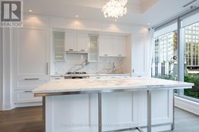Toronto (Annex) condo for rent - A white kitchen with a large island in the middle.