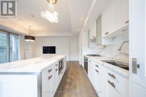 Toronto (Annex) condo for rent - A modern kitchen with white cabinets and a marble countertop.