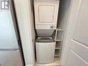 Vaughan (Concord) condo for rent - A white washing machine is in a small laundry room.