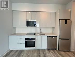 Vaughan (Concord) condo for rent - A kitchen with white cabinets and stainless steel appliances.