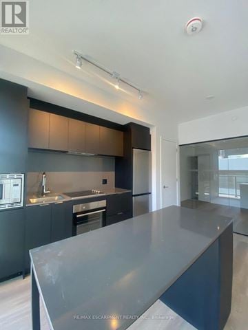 Hamilton (Beasley) condo for rent - A modern kitchen with dark cabinets and a large island.