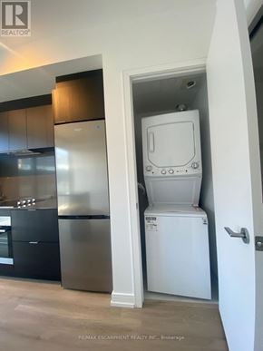 Hamilton (Beasley) condo for rent - A white dishwasher is in a kitchen with a black fridge and stove.