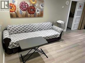 Vancouver apartment for rent - A grey and white sofa with a small table in front of it.