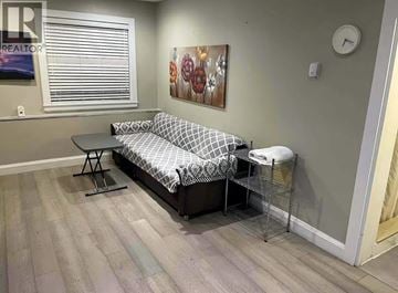 Vancouver apartment for rent - A living room with a grey sofa and a clock on the wall.