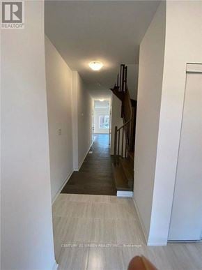 Barrie (Painswick South) townhouse for rent - A long hallway with white walls and wood flooring.