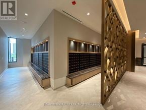 Vaughan (Concord) condo for rent - A modern interior space with a wooden staircase and a wall of black panels.