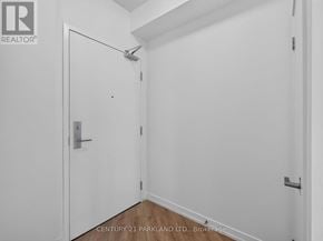 Toronto (Niagara) condo for rent - A white door with a silver handle is in a white room.