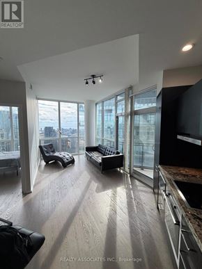 Toronto (Church-Yonge Corridor) condo for rent - A spacious living room with a view of the cityscape outside the large windows.